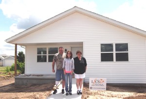 Delbert McGuirk, Shandie Reed and Jackie McGuirk in front of their newly built home.