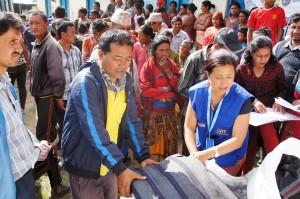LWF Nepal project coordinator Nibha Shresta hands out blankets to earthquake survivors in Ghusel