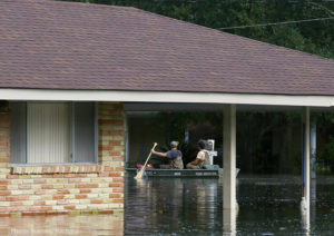 Residents use a boat to navigate through flood waters in Ascension Parish