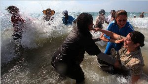 Palestinian women and children swim in the Mediterranean, some for the first time.
