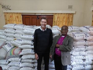 men standing in front of bags of meal