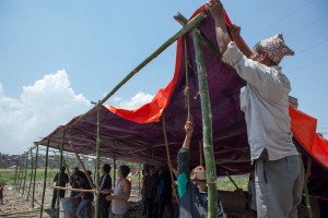 Locals in Byasi Tole, come togehter to build a temporary shed for the people in Byasi Tole, who have lost their homes following the earthquake.