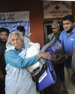 Volunteer distributes relief materials to earthquake victim at Jhaukhel in Bhaktapur. Photo: Dipesh Shrestha/LWF