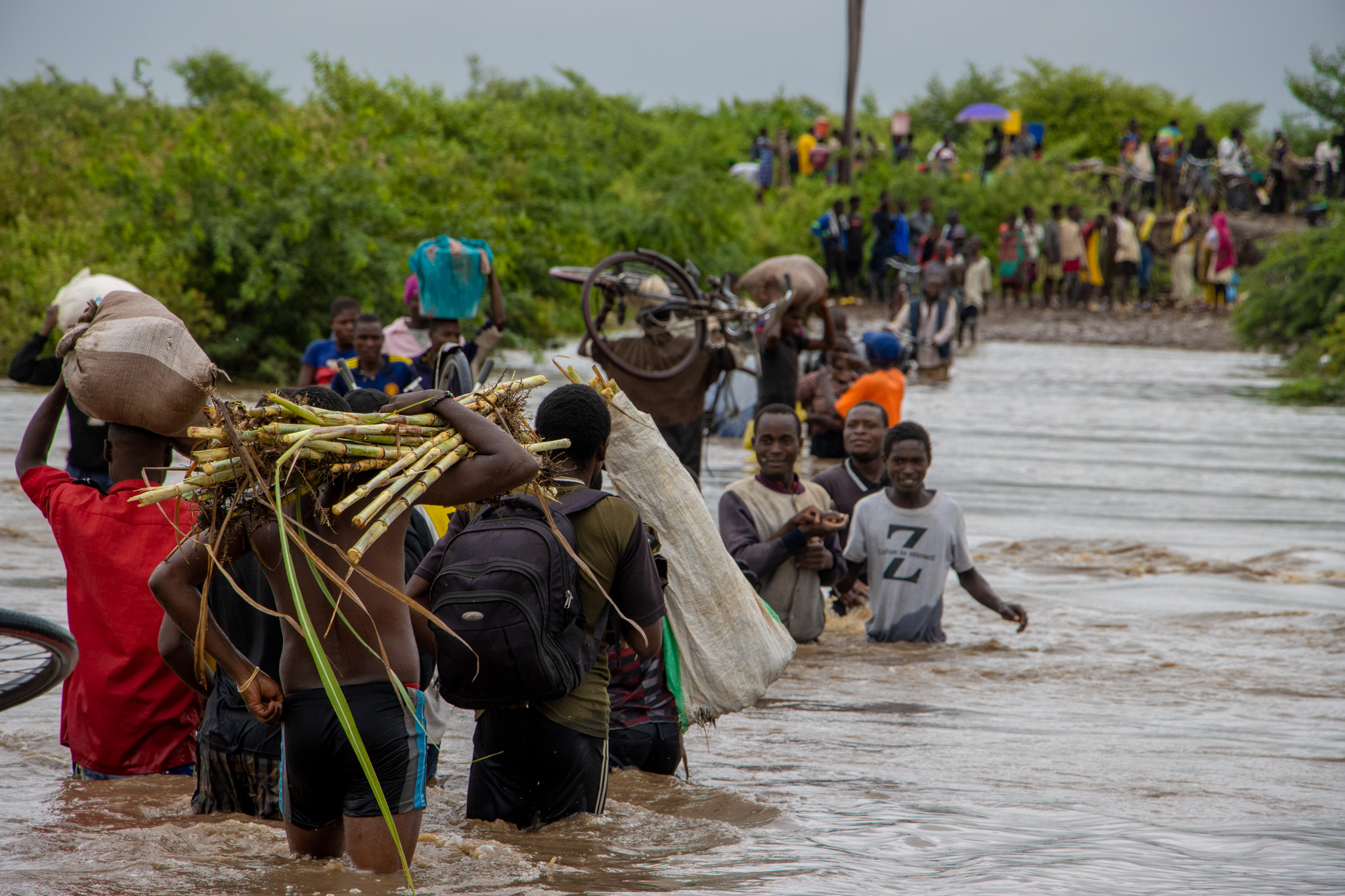 People walking through floodwaters.