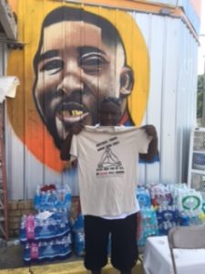 Jamal at the Triple S Convenience Store. T-shirt reads "Brothers Throw Down Your Guns! Jesus Died For Us All. His Blood Was Enough